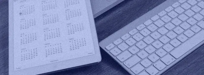 A tablet showing a calendar next to a keyboard
