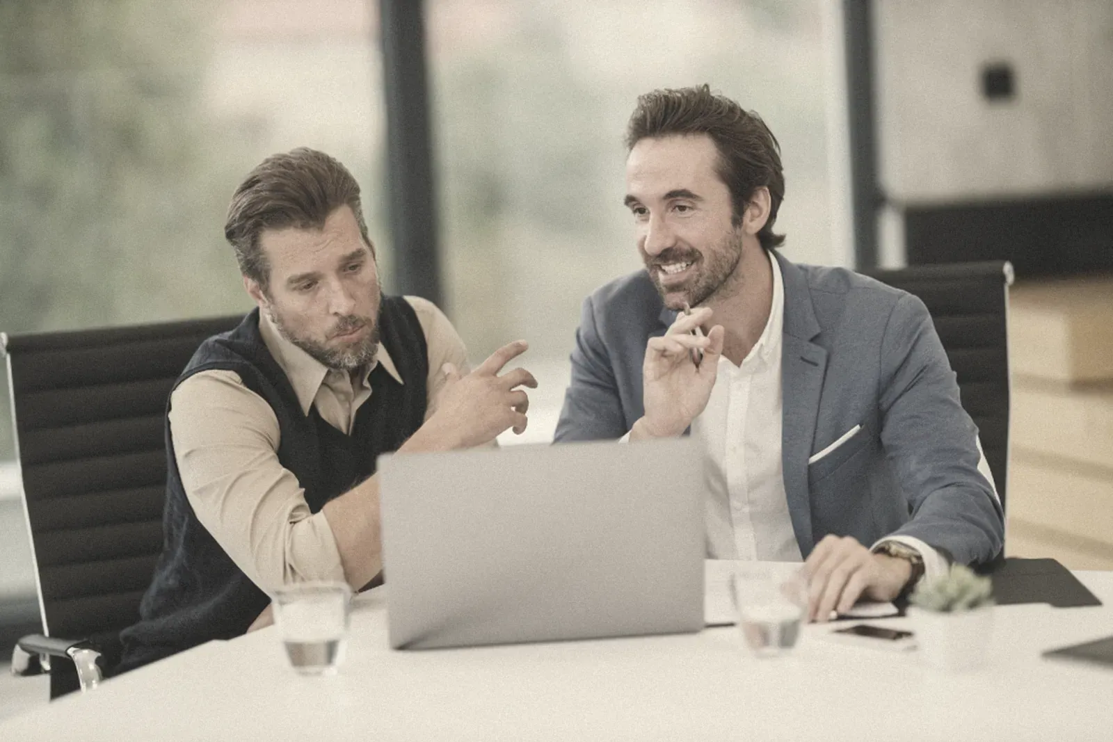 Two business people talking over a laptop