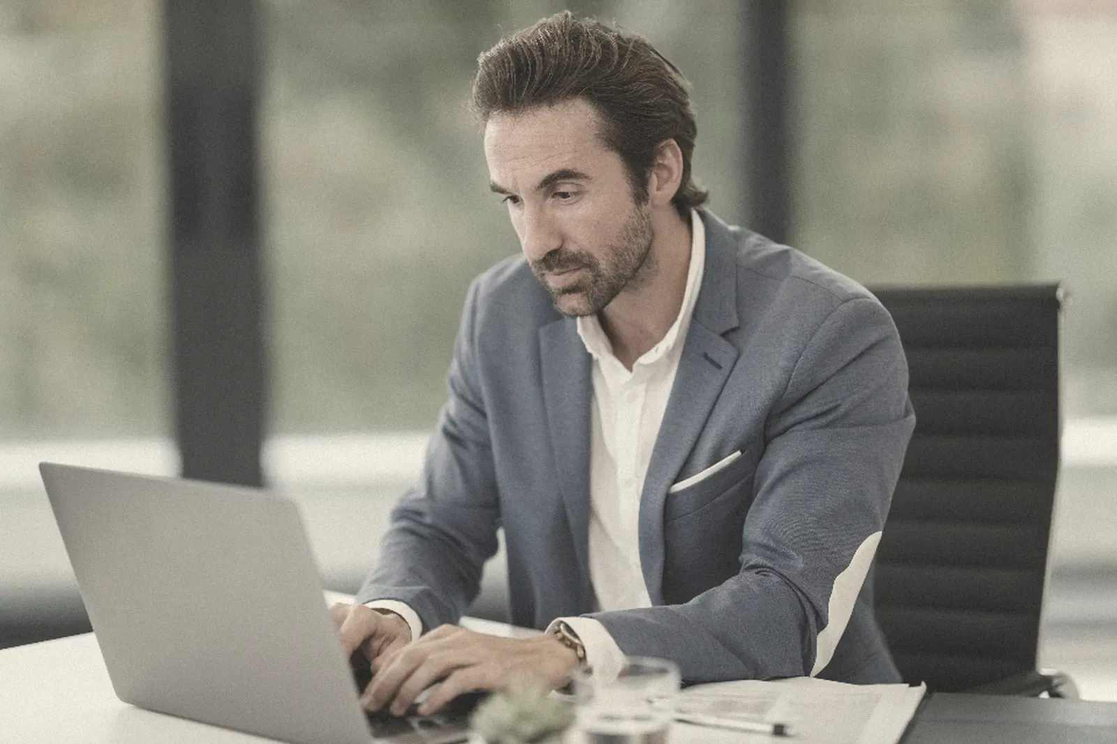 A businessman working on a laptop at his desk