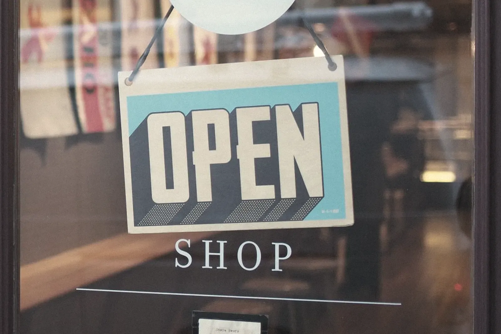 An open sign hanging in a shop window