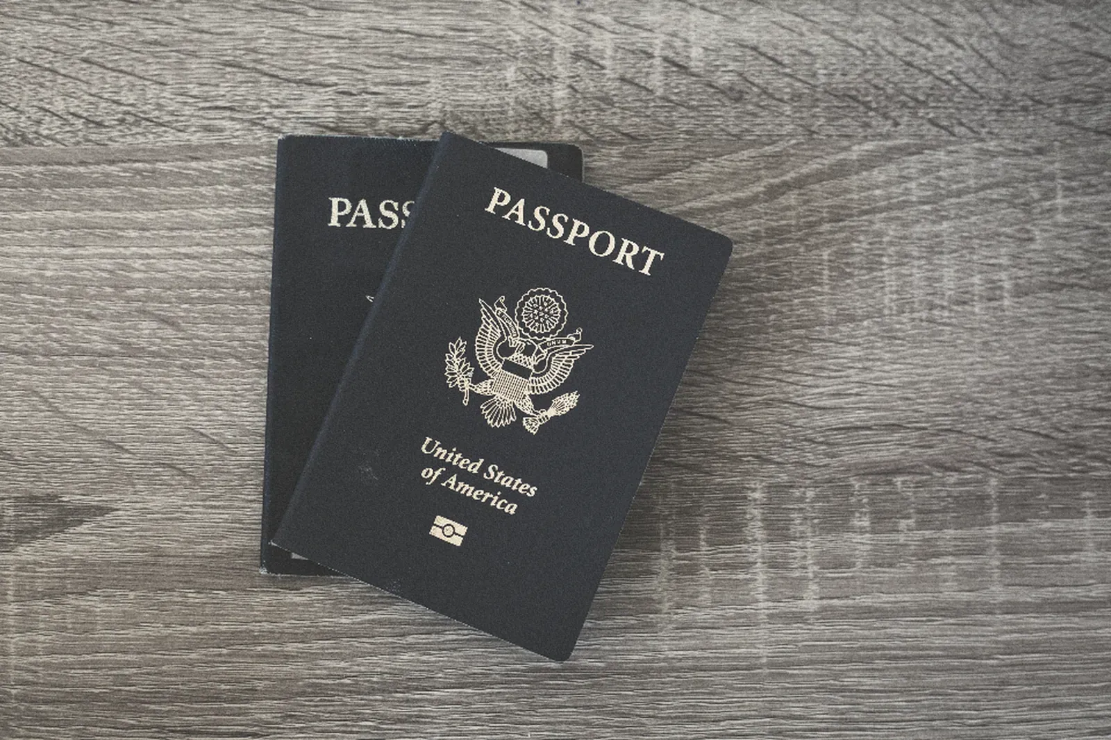 Two United States passports on a wooden table