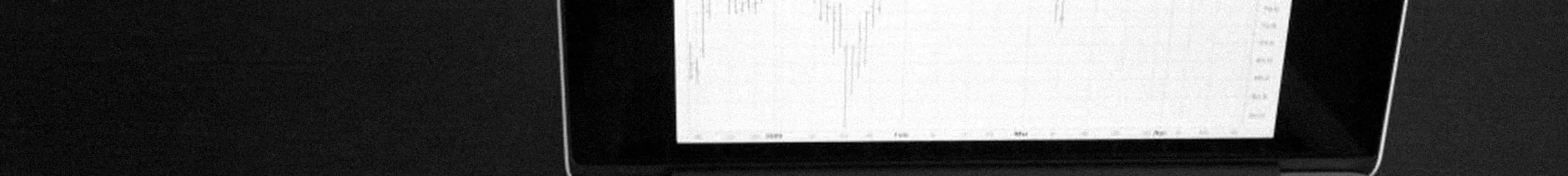 A laptop showing a line chart on a dark desk