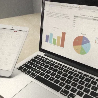 A laptop showing bar and pie charts
